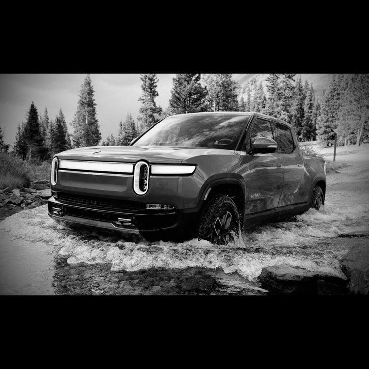 Rivian R1T water crossing a river in black and white